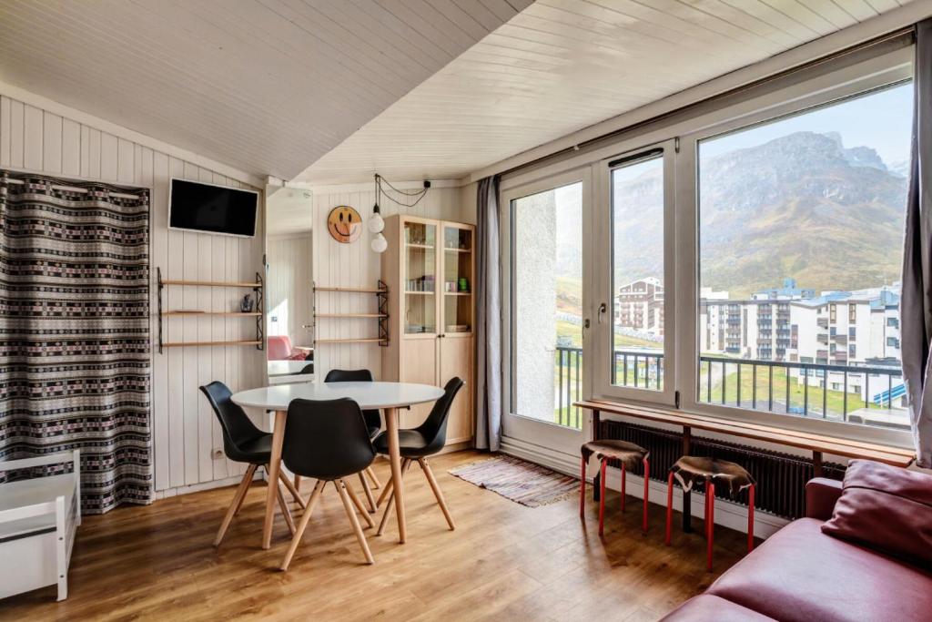 a living room with a table and chairs and a couch at Appartement à Tignes avec accès direct aux pistes 84390 in Tignes