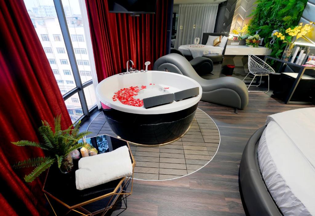Bonita Signature Hotel في مدينة هوشي منه: غرفة في الفندق مع حوض استحمام وسرير