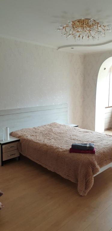 a bedroom with a bed and a chandelier at Apartament cu 2 odai in chirie or.Soroca in Soroca