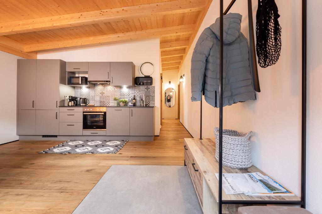 una sala de estar con una cocina con techos de madera. en Fichtenlodge Stubaital, en Neustift im Stubaital
