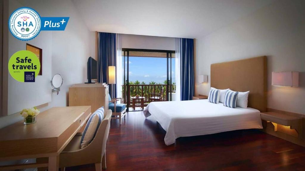 een hotelkamer met een bed en een bureau bij The Tide Resort in Bangsaen