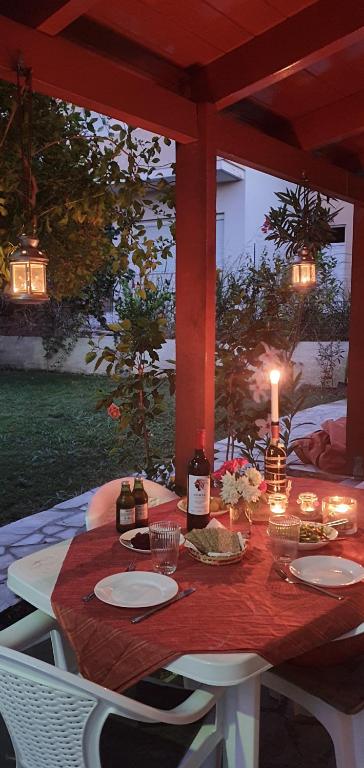 a table with candles and wine bottles on a patio at Ferienhaus Kreta Sonnenschein in Plataniás