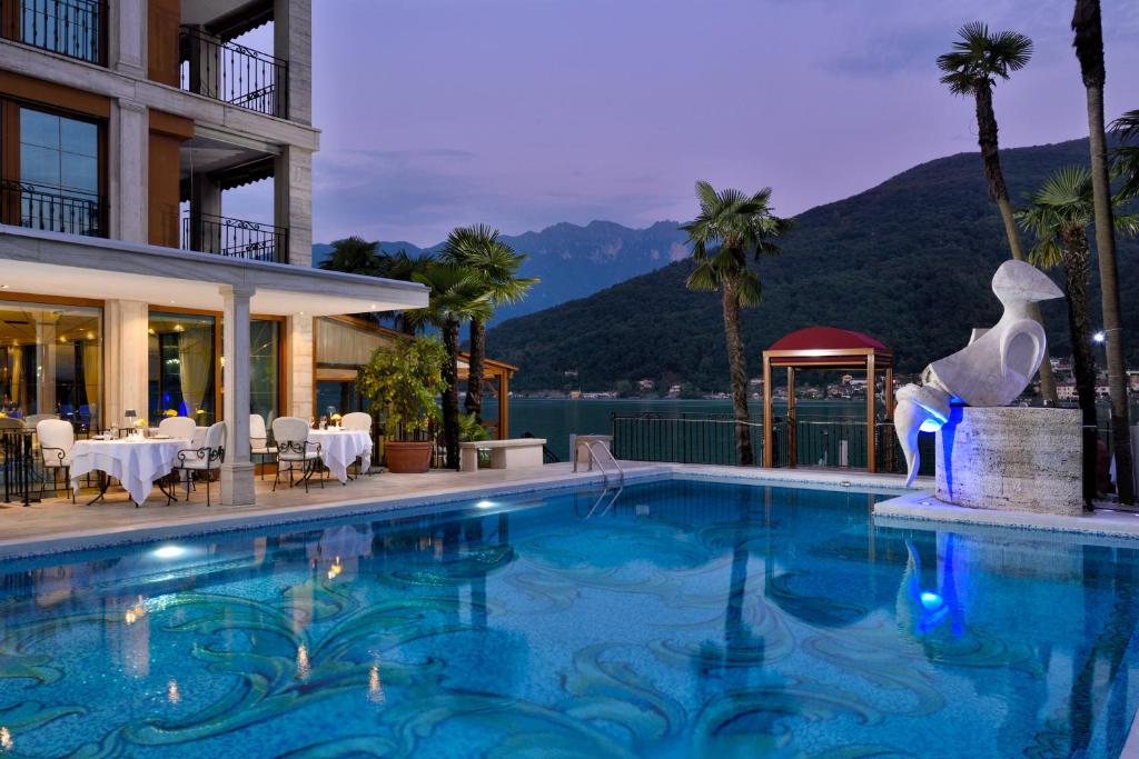 a pool at a hotel with a view of the mountains at Swiss Diamond Hotel & Spa in Morcote