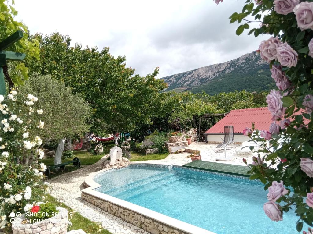a swimming pool in a yard with flowers at KATY&MLADEN in Baška