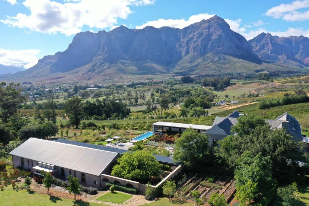 an aerial view of a farm with mountains in the background at De Zeven Guest Lodge in Stellenbosch