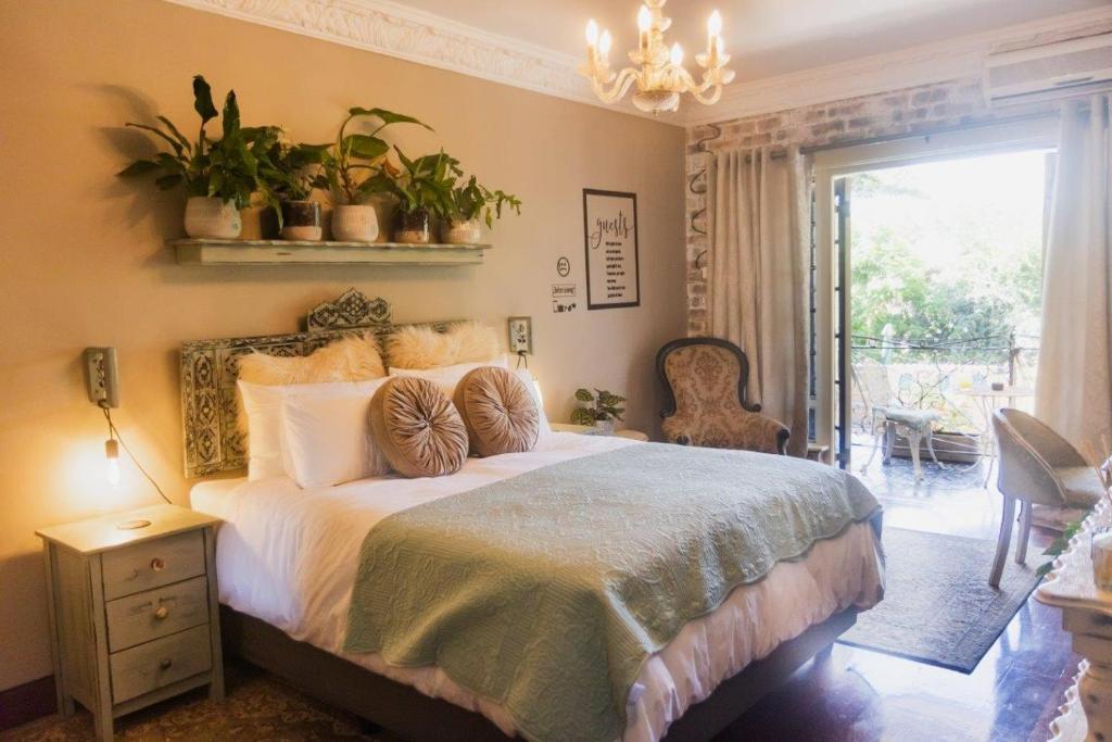 a bedroom with a bed with plants on the wall at La Casa Nostra Villa Rose Garden Amore in Hillcrest