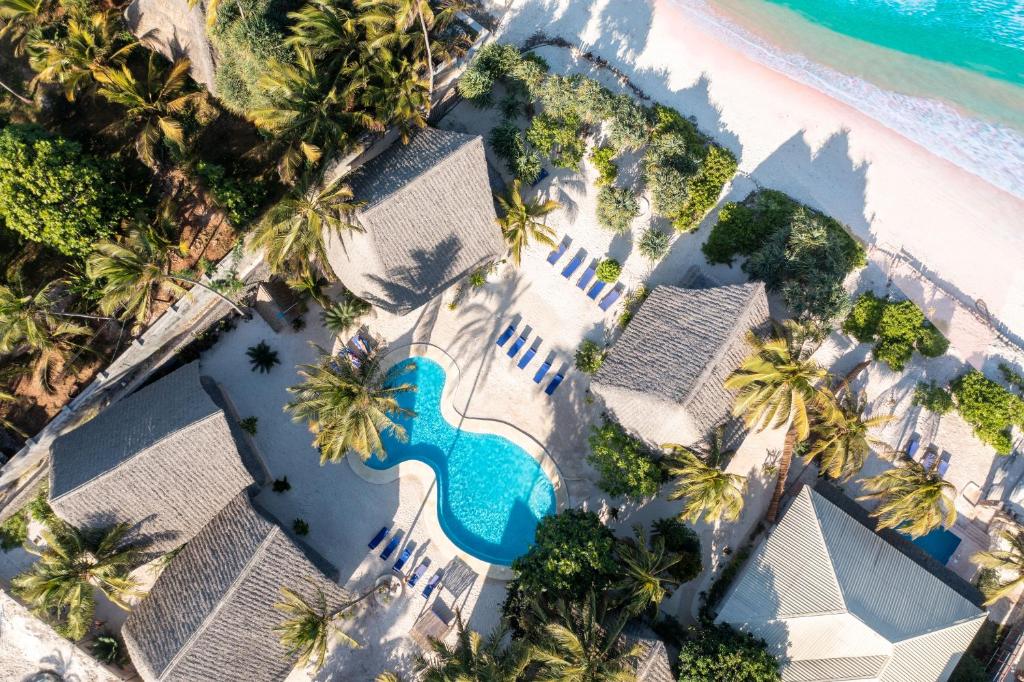 an aerial view of a resort with a pool and palm trees at Marafiki Beach Hotel & SPA in Matemwe