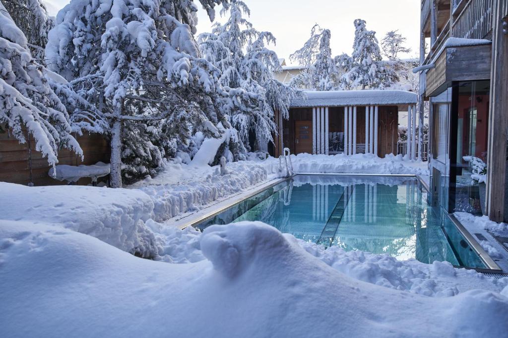ein schneebedeckter Pool neben einem Haus in der Unterkunft Small Luxury Hotel of the World - DasPosthotel in Zell am Ziller
