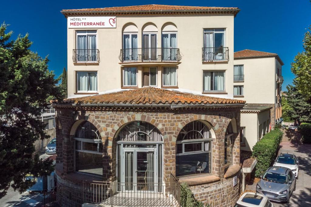 un edificio frente a un aparcamiento en Hôtel Miléade Méditerranée - Port-Fréjus, en Fréjus