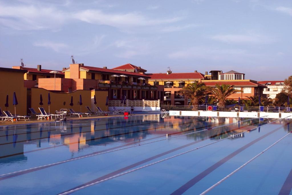 an empty swimming pool with buildings in the background at Continental Resort in Tirrenia