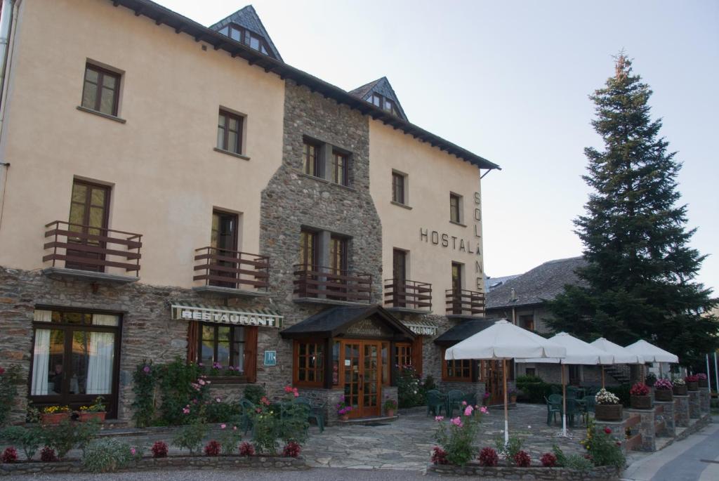 a large building with a tree in front of it at Sol i Neu in Ribera de Cardós