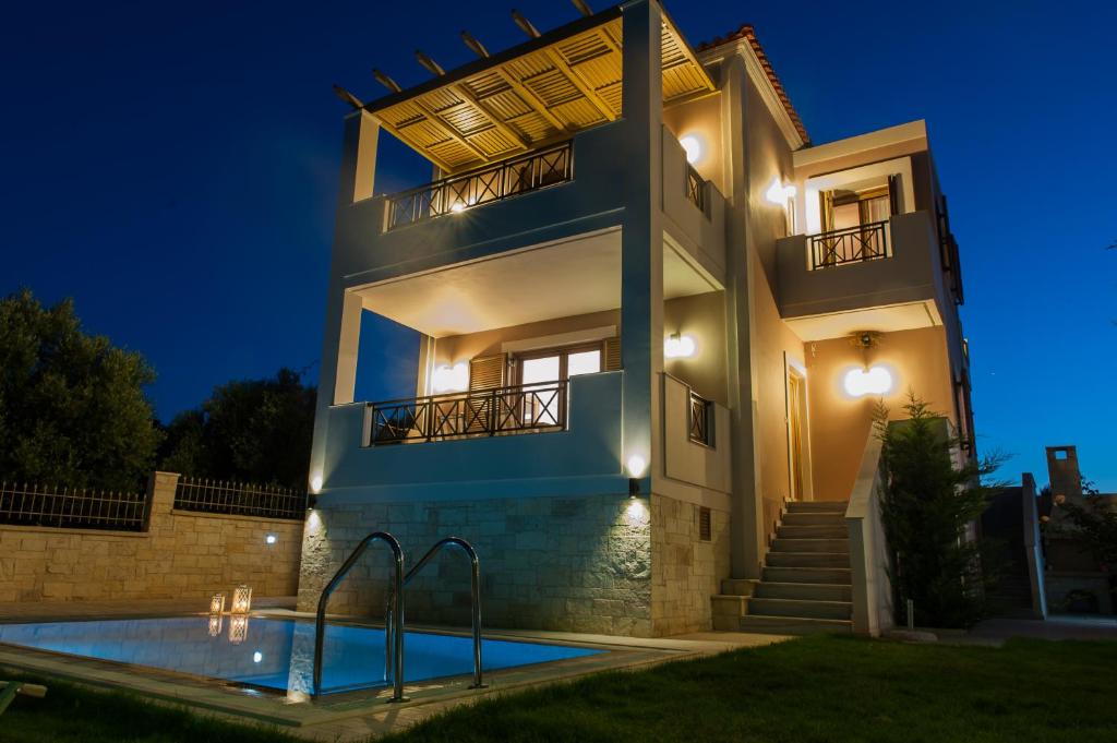 a villa with a swimming pool at night at Villa Harmony-Crete Residences in Adelianos Kampos