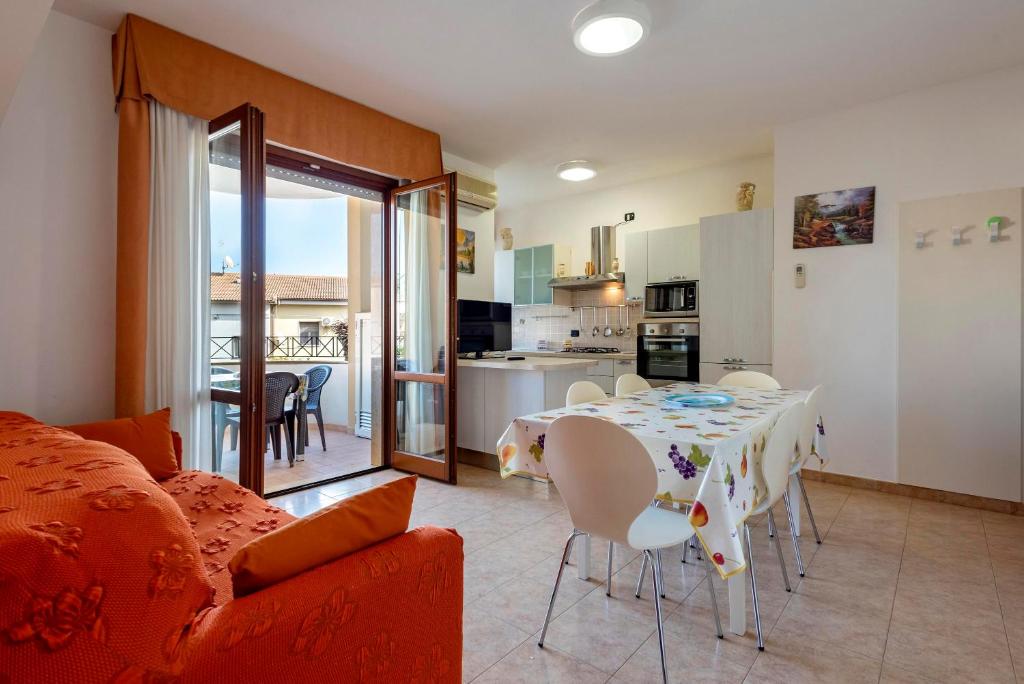 a living room with a dining table and a kitchen at Egeo apartment in Alghero