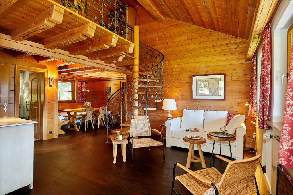 un soggiorno con divano bianco e pareti in legno di Haus Waldeck a Reit im Winkl