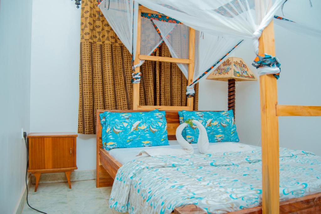 a bedroom with a bed with a canopy at The Belle View Inn Bed & Breakfast in Moshi