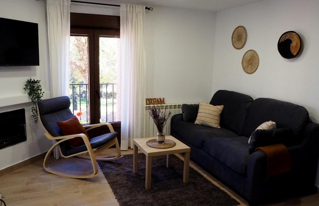 sala de estar con sofá azul y silla en La Casa de los Abuelos Valentín, en Pinilla del Valle