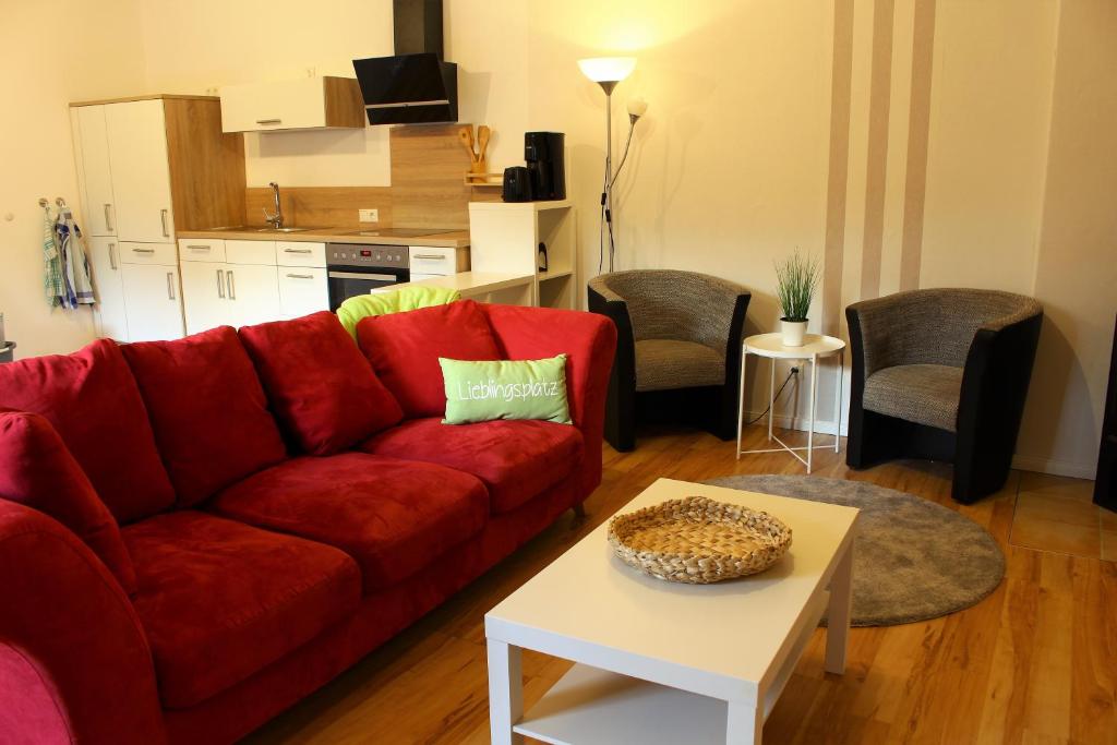 a living room with a red couch and a table at Ferienwohnung Naturpark Schlei in Güby