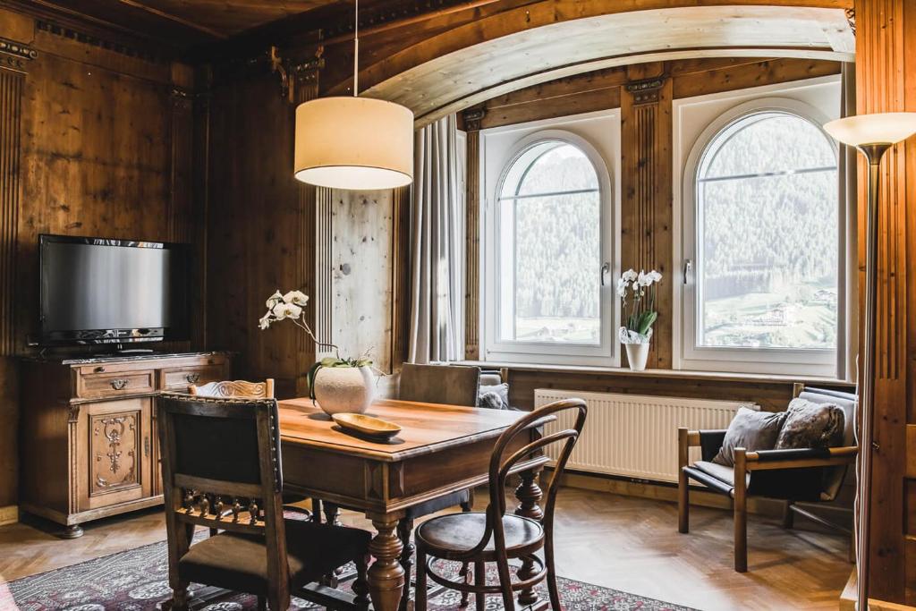 Villa Martiner Apartments Moritz في أورتيساي: غرفة طعام مع طاولة وكراسي خشبية