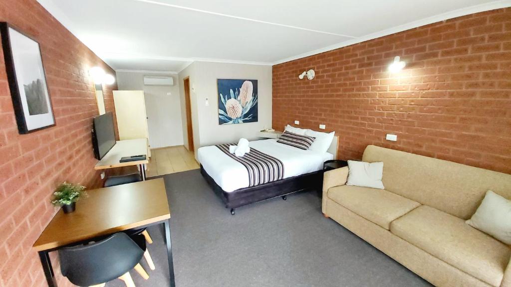 um quarto de hotel com uma cama e um sofá em Country Mile Motor Inn em Forbes