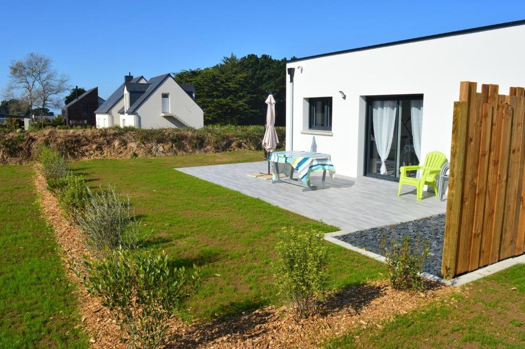 eine Terrasse mit einem Tisch und Stühlen neben einem Haus in der Unterkunft Gite de Ker Ravel in Penvénan