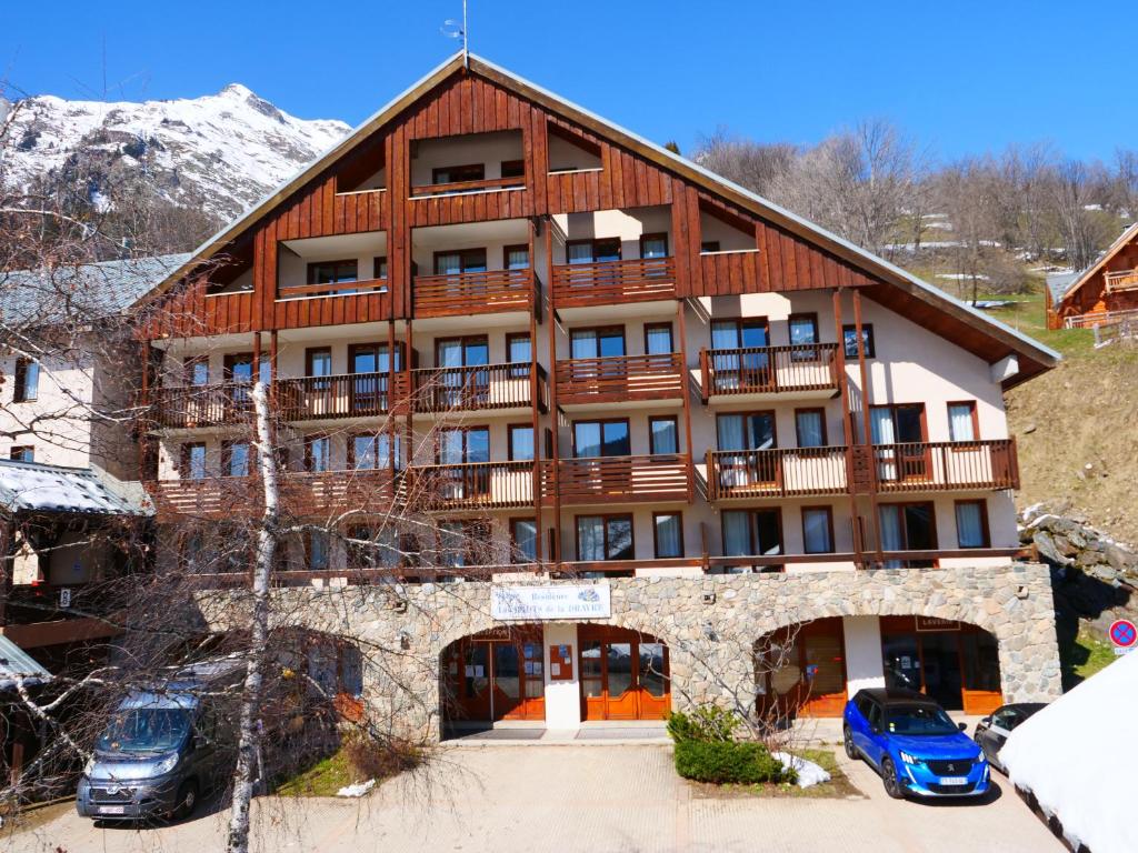 a large building with cars parked in front of it at Vacancéole - Les Hauts de la Drayre in Vaujany