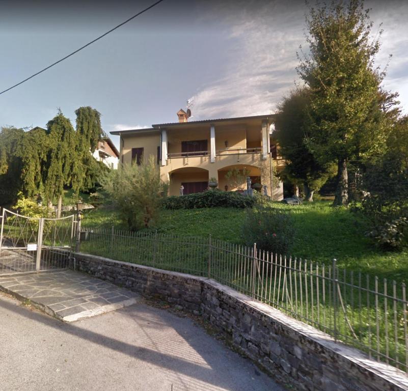 ein Haus mit einem Zaun davor in der Unterkunft Villa Dei Cedri in Asso