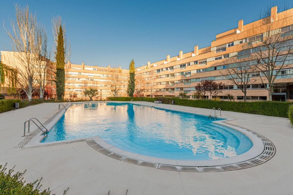 a large swimming pool in front of a building at Los Olivos Stylish Apartments in Conde Orgaz Area in Madrid