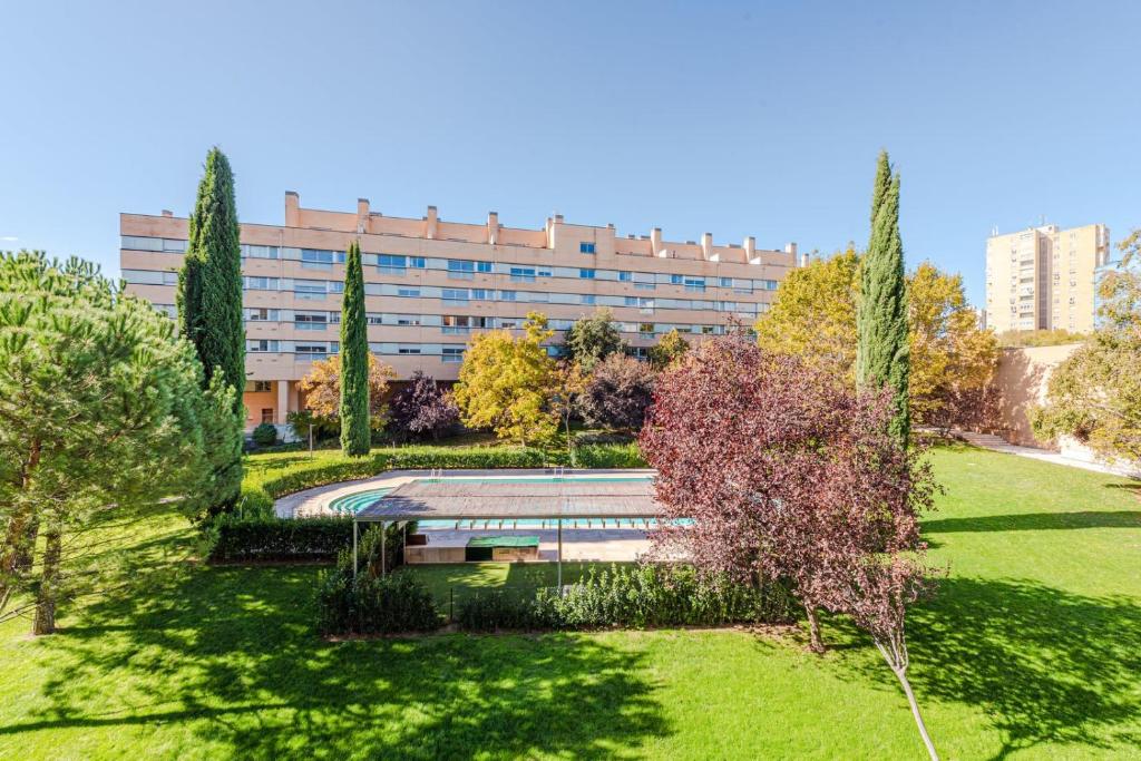 un parc avec un bâtiment en arrière-plan dans l'établissement Las Encinas Design Apartment in Conde Orgaz Area - Madrid, à Madrid