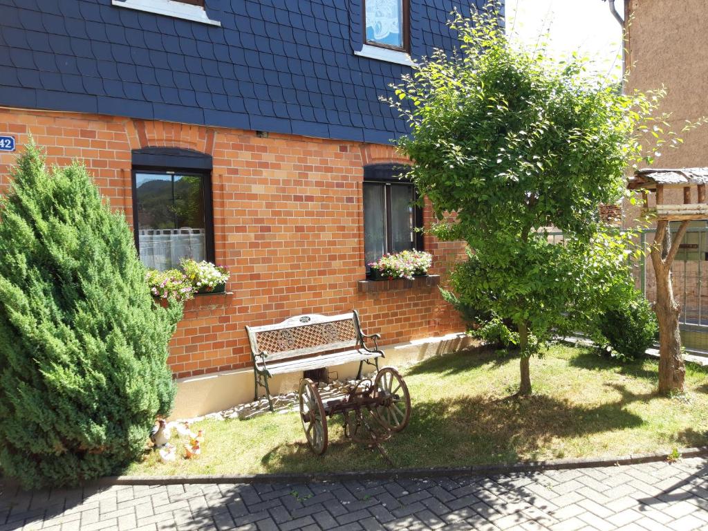 a bench sitting in front of a brick building at Ferienwohnung Jahns Hof in Rudolstadt