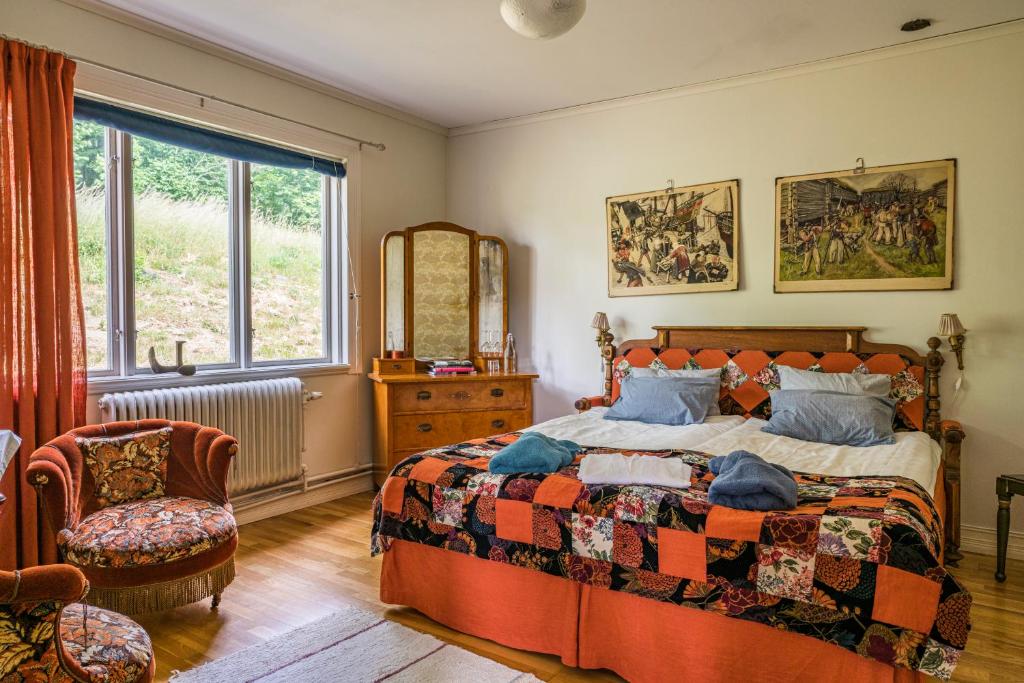 a bedroom with a bed and a chair and a window at Boråkra Bed & Breakfast in Karlskrona