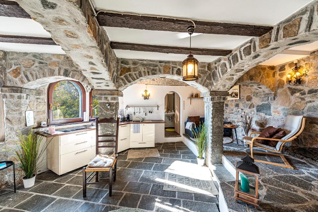 uma cozinha e sala de estar com uma parede de pedra em Casa Alma Grotto em Brione sopra Minusio
