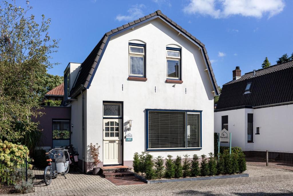 una casa blanca con techo negro en B&B De Mansarde, en Apeldoorn