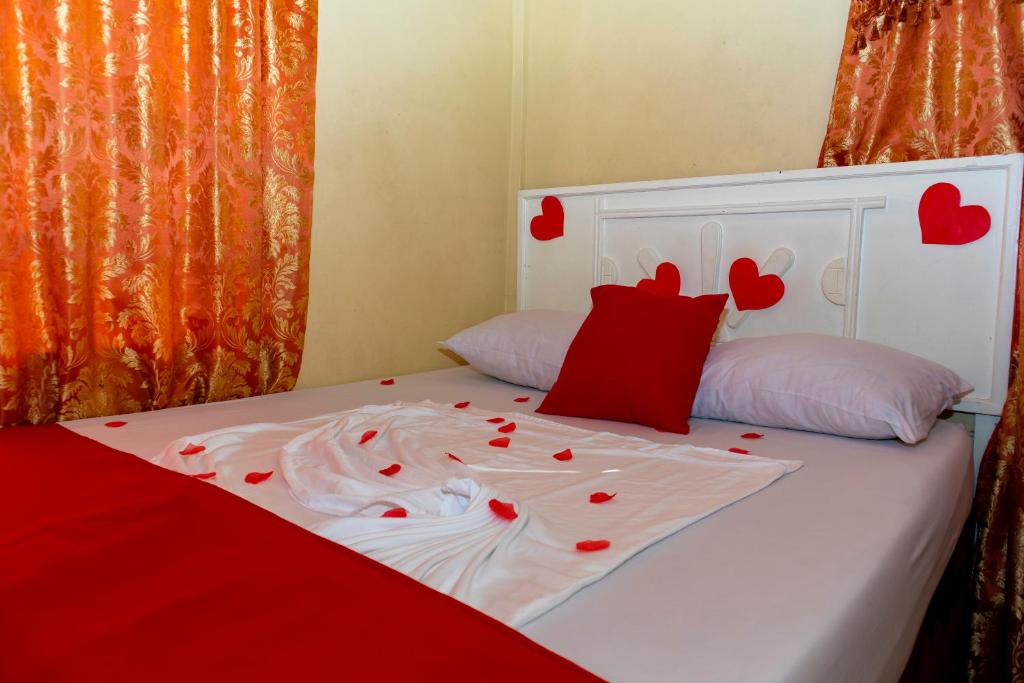 a bed with red hearts on top of it at Harmony Inn & Secret Villa in Georgetown