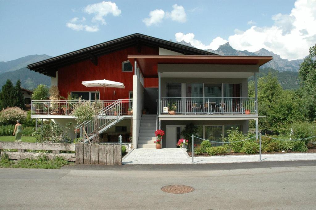 a red house with a porch and a balcony at Apartment Bachmann in Bludenz