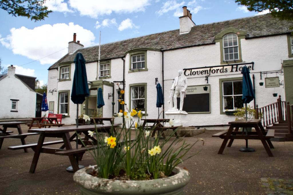 a group of picnic tables in front of a inn at The Clovenfords Hotel in Clovenfords