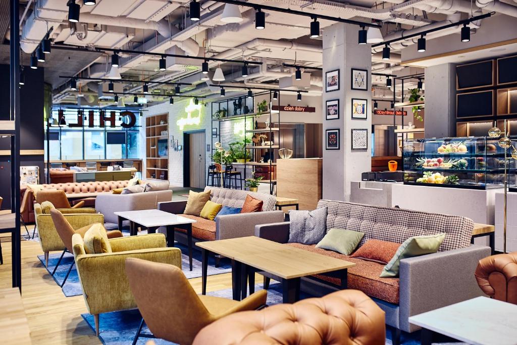 a restaurant with couches and tables and chairs at ibis Styles Kraków Centrum in Krakow