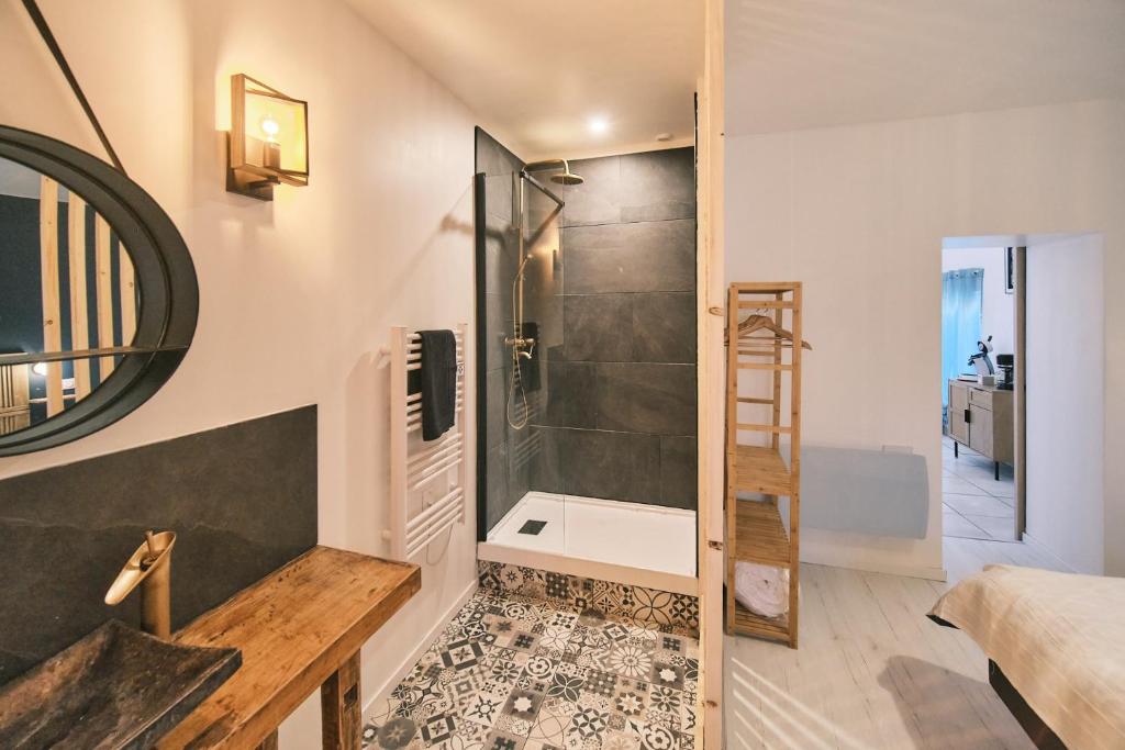 a bathroom with a shower and a wooden table at Chez Nico et Anne in Deyvillers