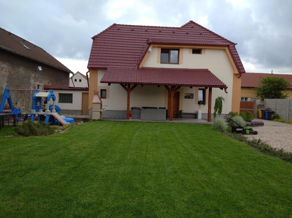 ein Haus mit einem Hof mit Spielplatz in der Unterkunft Apartmány Opolany in Opolany