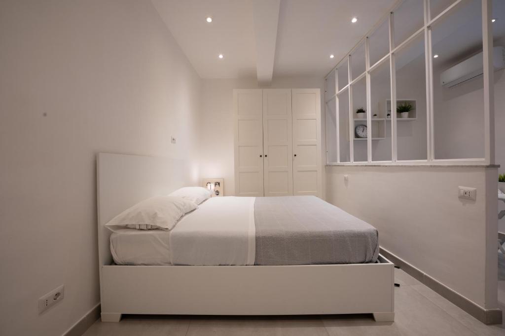 biała sypialnia z łóżkiem i białymi szafkami w obiekcie Casa Vacanze Santa Teresella 40 w mieście Neapol