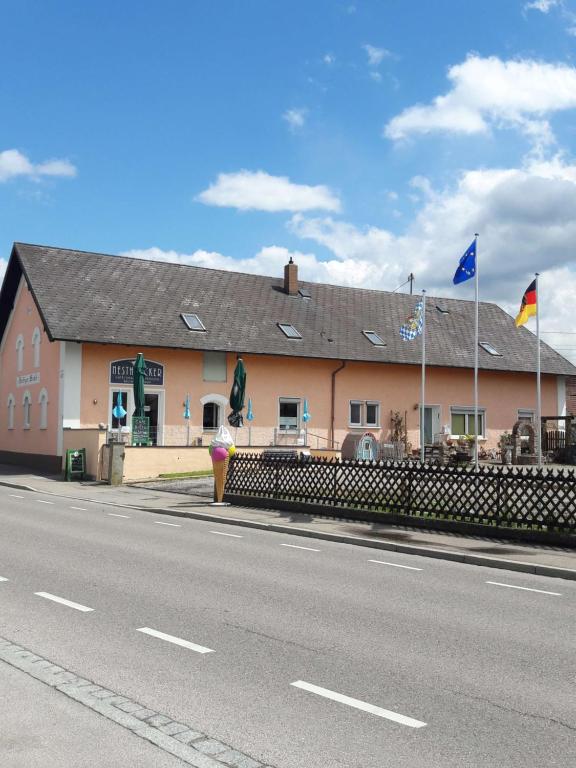 um edifício ao lado de uma estrada com bandeiras em "Nesthocker" Café-Snackbar-Pension-Bauwagencamp em Offingen