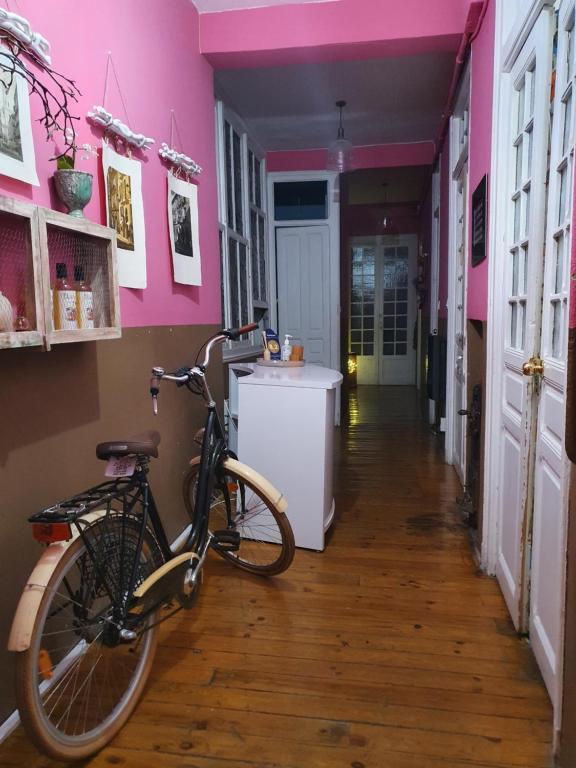 una bicicleta estacionada en un pasillo con paredes rosas en ThePlacetoBe B&B, en Valladolid