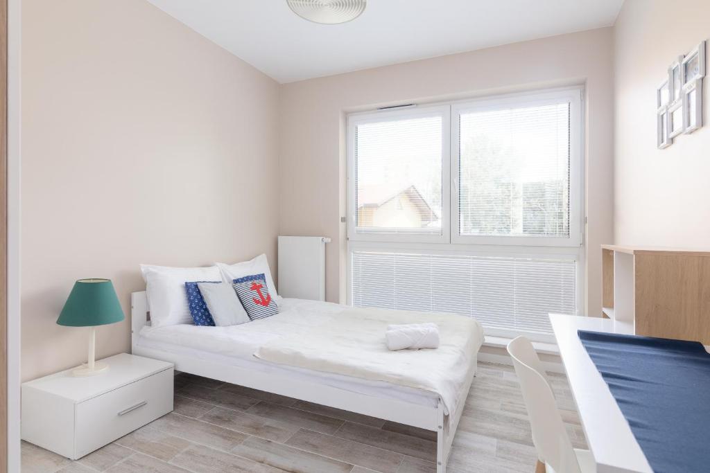 - une chambre blanche avec un lit et une fenêtre dans l'établissement Metro Wilanowska Comfortable Apartment, à Varsovie