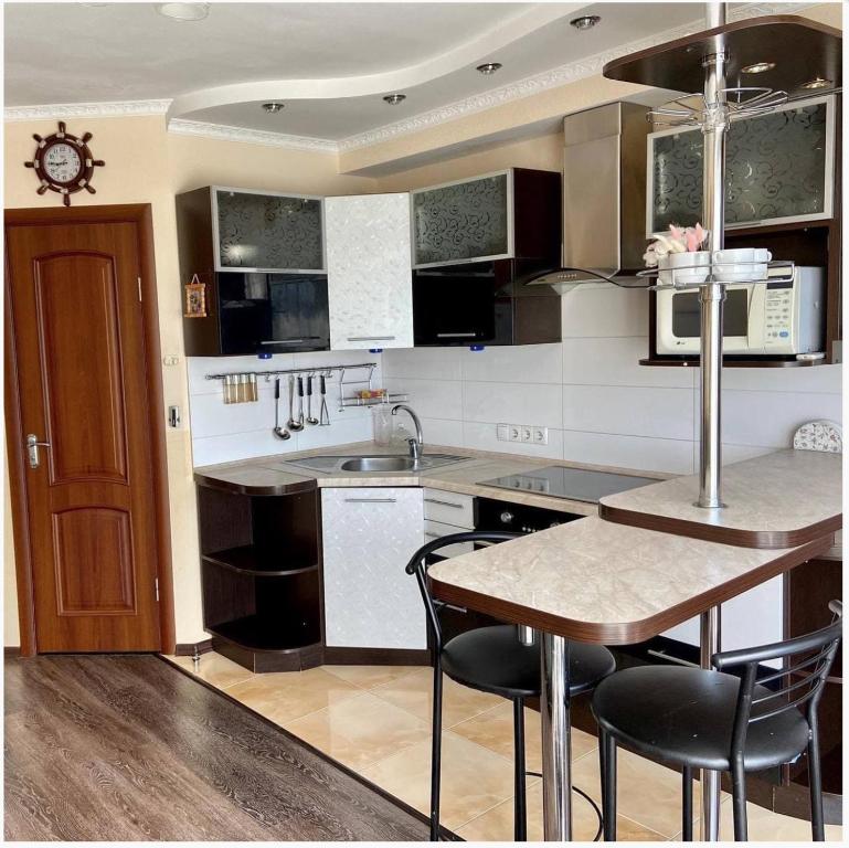 uma cozinha com uma mesa e algumas cadeiras em 3-bedroom apartment Most City area em Dnipro