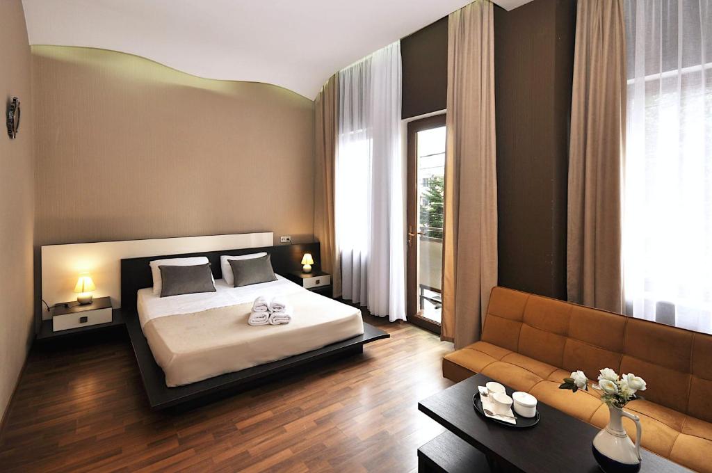 ein Schlafzimmer mit einem Bett und einem Sofa in der Unterkunft Hotel Majestic in Tbilisi City