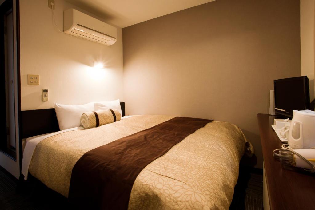 Postel nebo postele na pokoji v ubytování Kakegawa Station Hotel