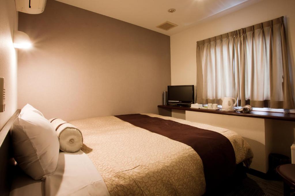 Postel nebo postele na pokoji v ubytování Kakegawa Station Hotel