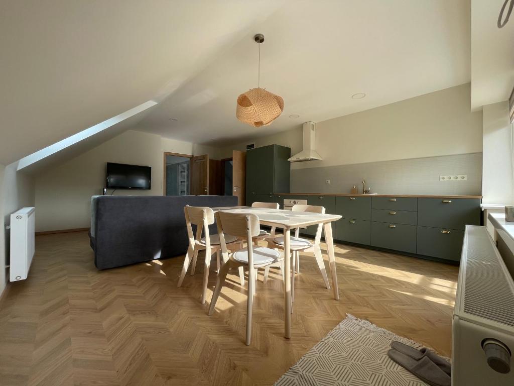 a kitchen and dining room with a table and chairs at Koliko apartman in Mohács