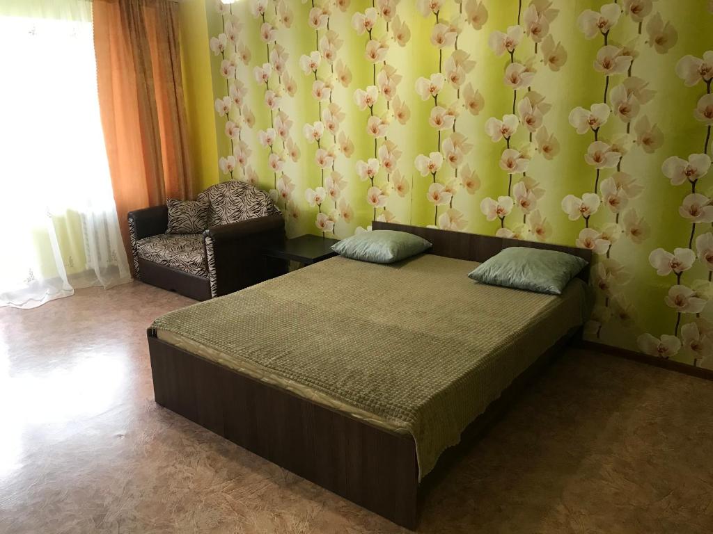 TuymazyにあるApartment on Komarova 31のベッドルーム1室(ベッド1台、椅子付)
