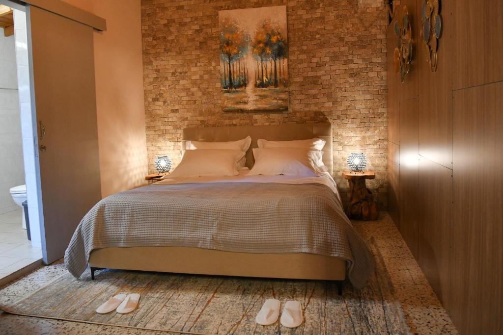 1 dormitorio con cama y pared de ladrillo en Sophias Cottage, en Askas