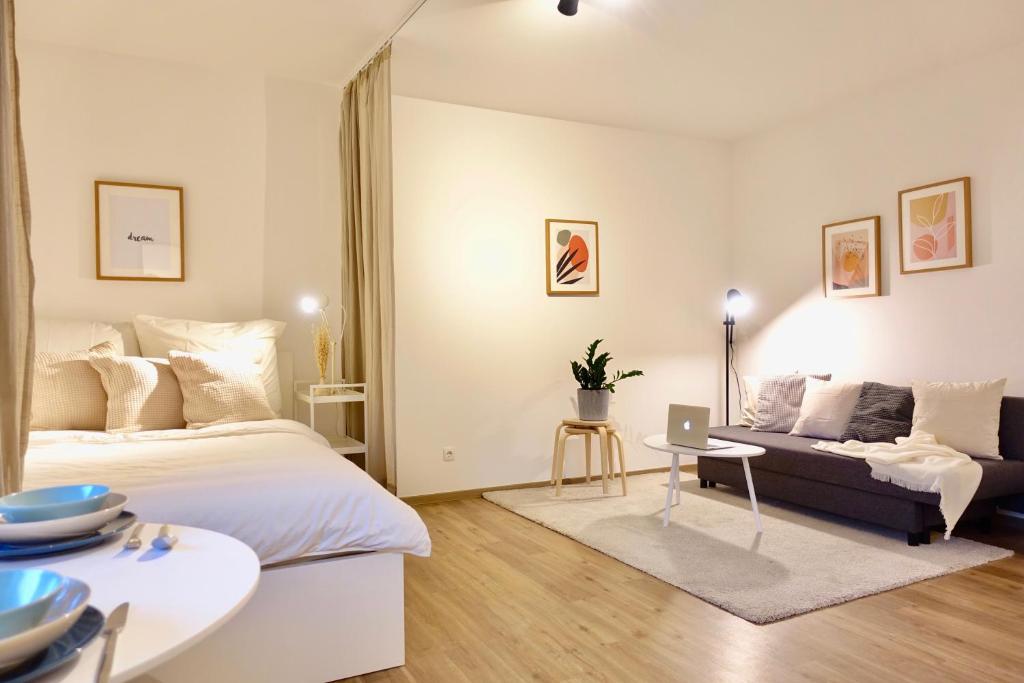 1 dormitorio con cama, sofá y mesa en NEU - gemütliches und modernes Apartment mit Stellplatz, en Coblenza